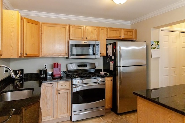 kitchen featuring crown molding, light tile patterned flooring, a sink, dark stone countertops, and stainless steel appliances