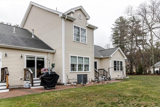 back of property featuring a yard, a patio, central AC, and a shingled roof