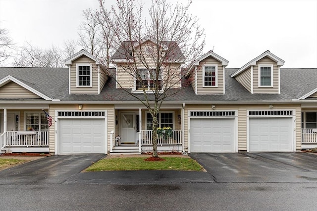 view of front of house featuring a shingled roof, a porch, and aphalt driveway