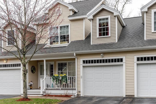 view of front of property featuring covered porch, driveway, roof with shingles, and a garage