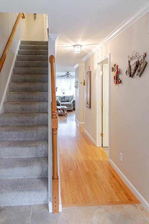 staircase with baseboards, ornamental molding, and tile patterned flooring
