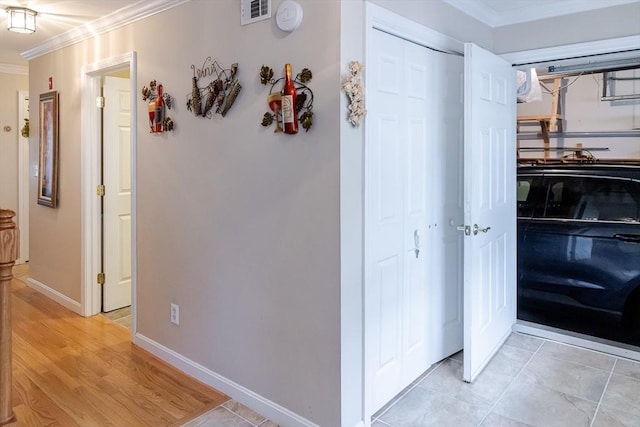 corridor with visible vents, ornamental molding, and baseboards
