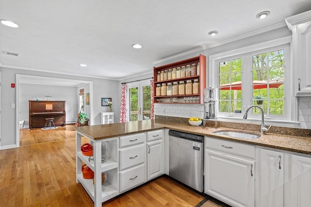 kitchen with stainless steel dishwasher, open shelves, a sink, white cabinets, and crown molding