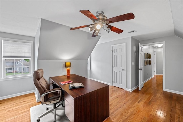 home office with ceiling fan, vaulted ceiling, light wood-style floors, and baseboards