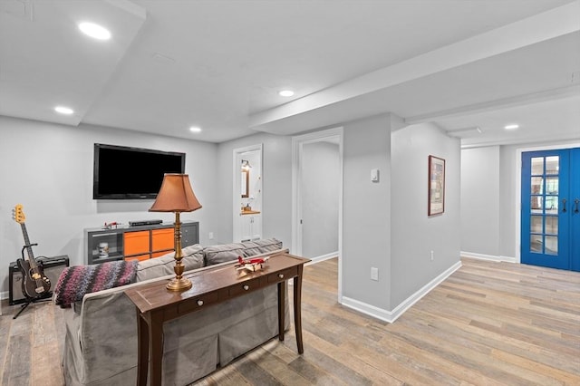 living room with baseboards, light wood-style floors, recessed lighting, and french doors