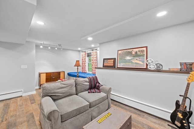 living area with a baseboard heating unit, hardwood / wood-style floors, recessed lighting, and baseboards