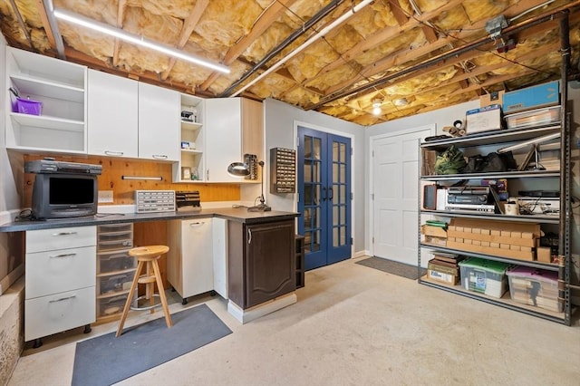 kitchen with open shelves, french doors, white cabinets, concrete floors, and dark countertops