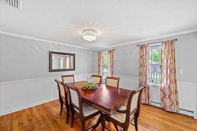 dining room featuring light wood-style floors, a chandelier, and ornamental molding