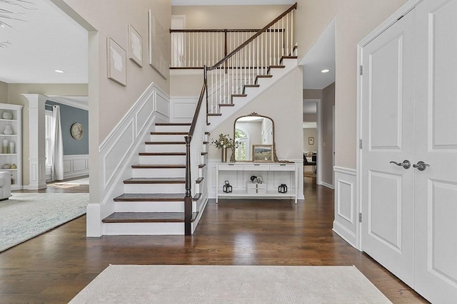 132 Hemmingway Pl, Wrentham, MA 02093 - staircase with a decorative wall, wood finished floors, a wainscoted wall, and a towering ceiling