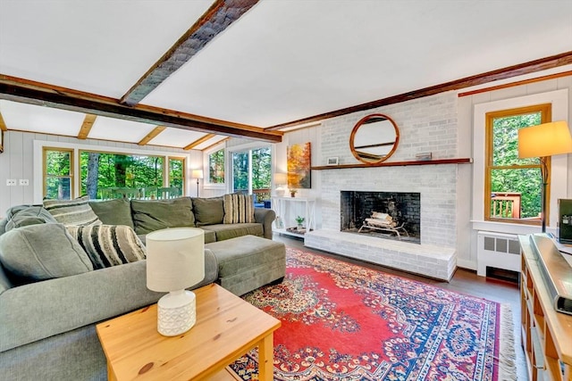 26 Beacon St, Amesbury, MA 01913 - living room featuring radiator, healthy amount of natural light, a brick fireplace, wood finished floors, and crown molding