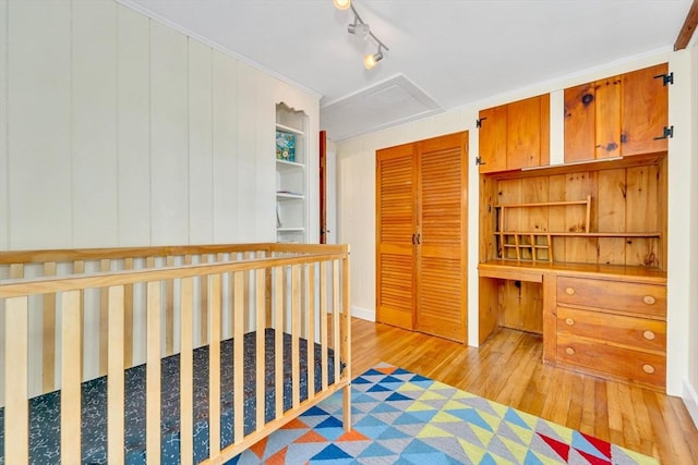 26 Beacon St, Amesbury, MA 01913 - bedroom with wood-type flooring, a closet, attic access, and built in desk