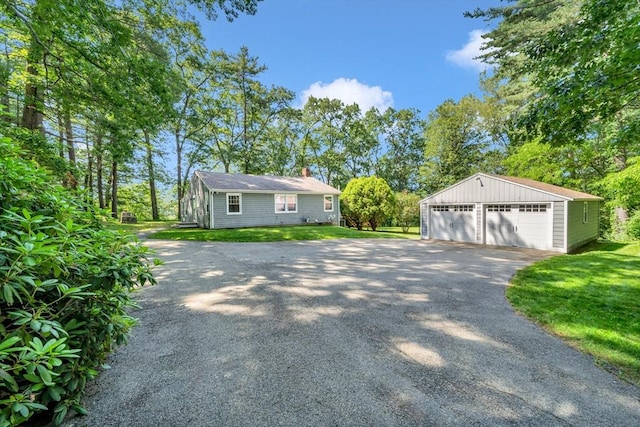 26 Beacon St, Amesbury, MA 01913 - view of front of house with a garage, an outdoor structure, a chimney, and a front yard