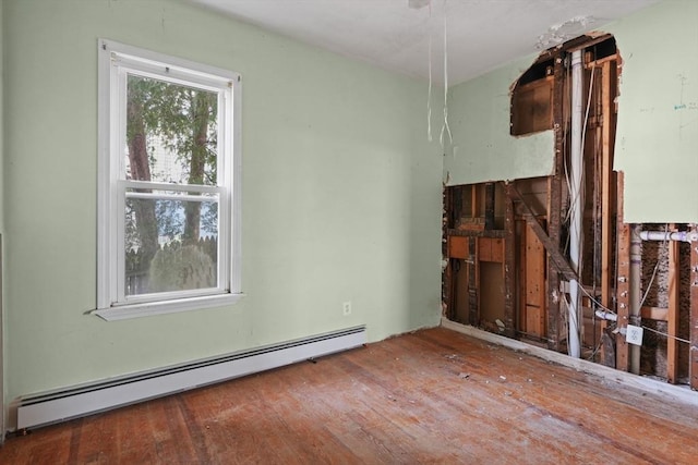 spare room featuring hardwood / wood-style flooring and a baseboard heating unit