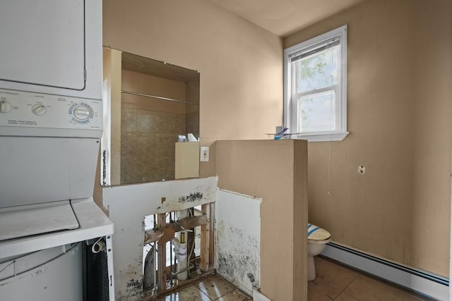 washroom with stacked washer / dryer, light tile patterned floors, and a baseboard radiator