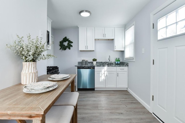 kitchen featuring baseboards, a sink, white cabinets, dishwasher, and light wood-type flooring