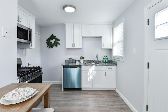 kitchen with plenty of natural light, white cabinets, and appliances with stainless steel finishes