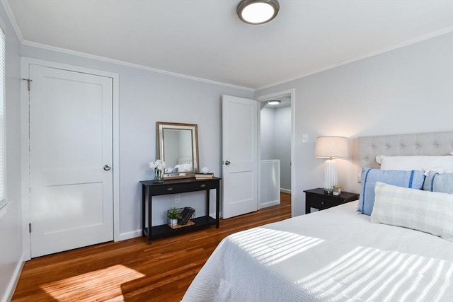 bedroom featuring baseboards, wood finished floors, and ornamental molding