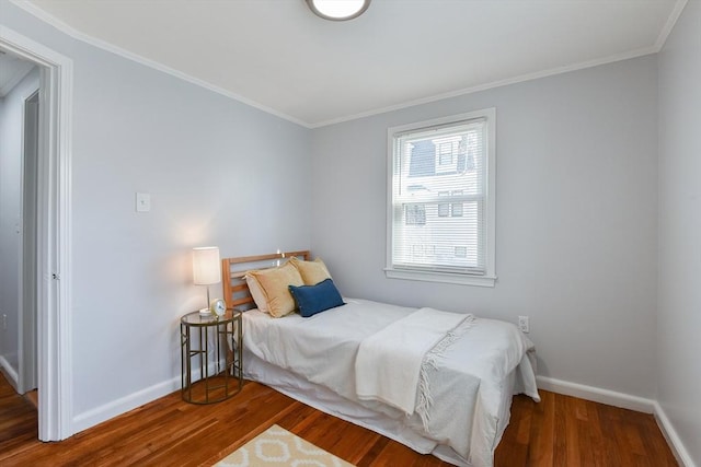 bedroom featuring crown molding, baseboards, and wood finished floors