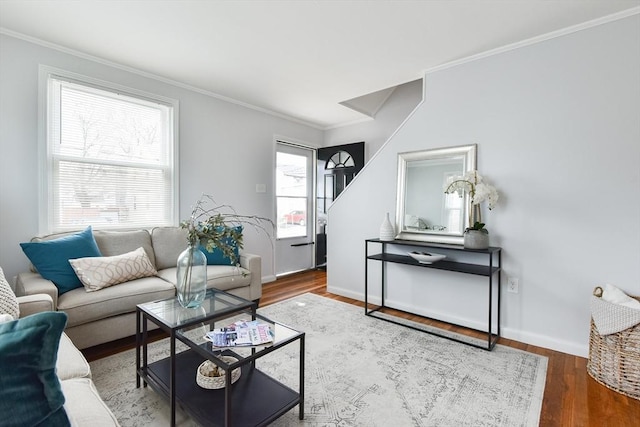 living room with crown molding, baseboards, and wood finished floors