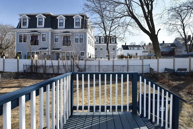 wooden terrace featuring a fenced backyard and a residential view