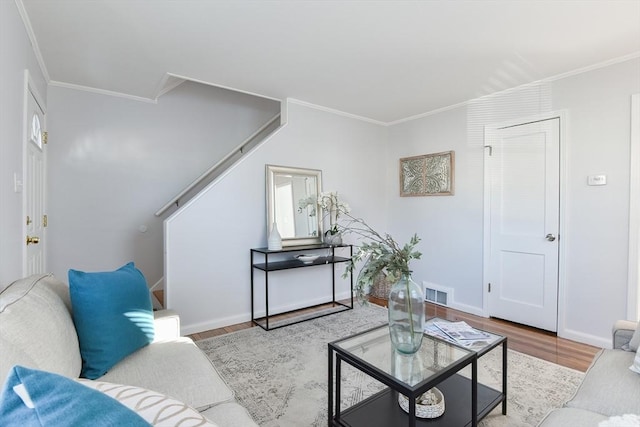 living room featuring visible vents, crown molding, and wood finished floors