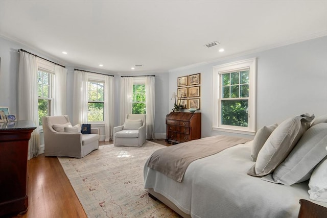 bedroom featuring crown molding, wood finished floors, and recessed lighting