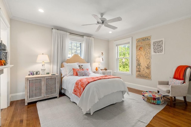 bedroom featuring multiple windows, crown molding, wood finished floors, baseboards, and recessed lighting