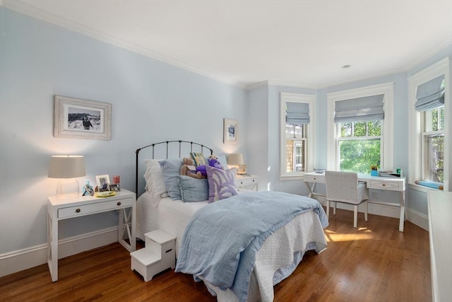 bedroom with wood finished floors, crown molding, baseboards, and an office area