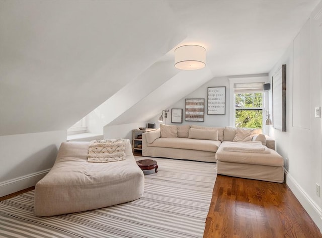 living room with wood finished floors, vaulted ceiling, and baseboards