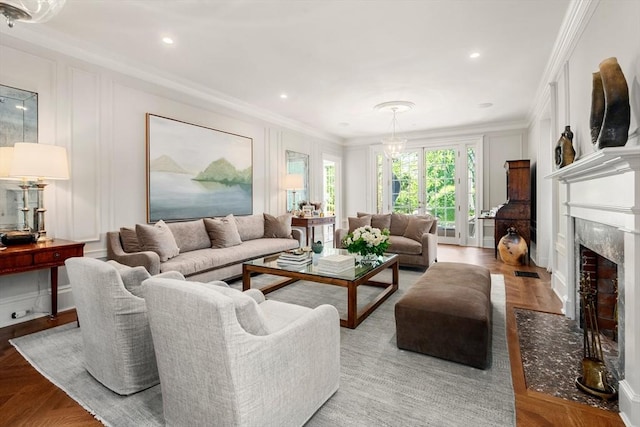 living room with a decorative wall, ornamental molding, a premium fireplace, and recessed lighting
