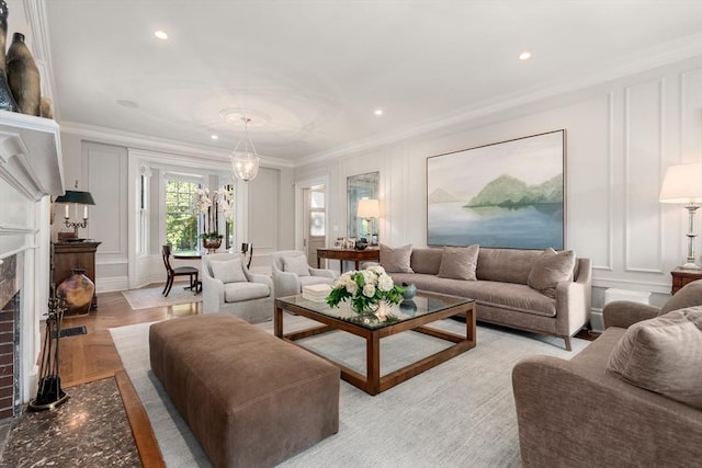 living area featuring a decorative wall, crown molding, recessed lighting, and a brick fireplace