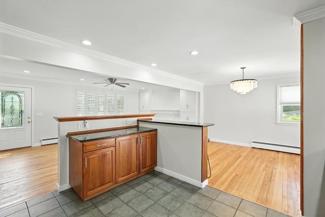 15 Oak Bluff Cir, East Longmeadow, MA 01028 - kitchen with a baseboard heating unit, light tile patterned flooring, dark countertops, a chandelier, and ornamental molding
