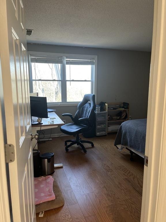 bedroom with hardwood / wood-style flooring, a desk, and a textured ceiling
