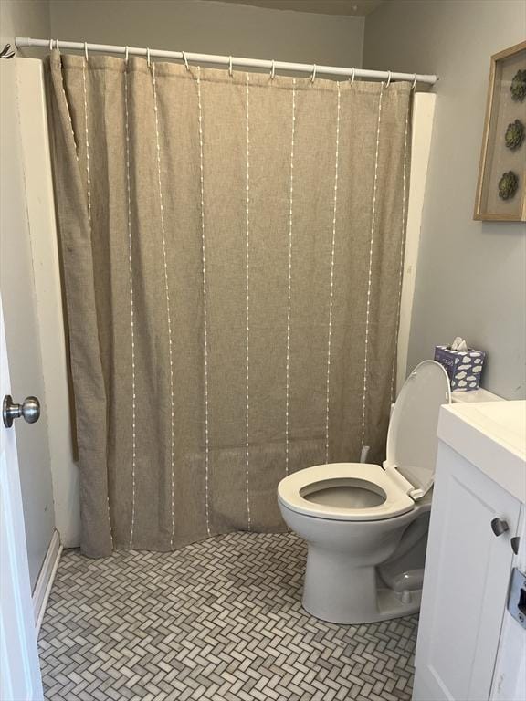 bathroom with toilet, tile patterned flooring, and vanity