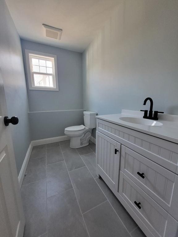 bathroom with tile patterned flooring, vanity, and toilet