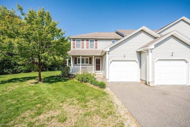 view of front of property featuring an attached garage, asphalt driveway, covered porch, and a front yard