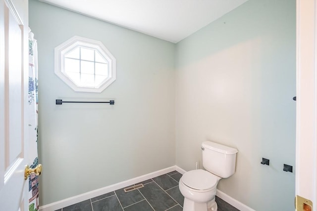 bathroom featuring toilet and baseboards