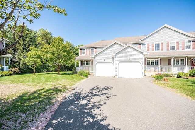 view of front facade featuring a porch, driveway, a front lawn, and an attached garage