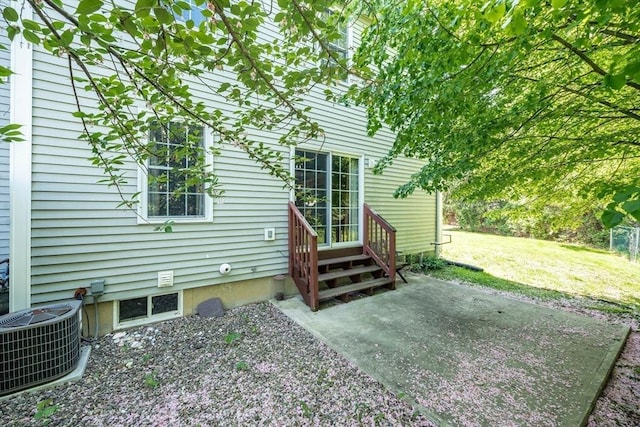 rear view of property featuring central air condition unit, a patio area, a yard, and entry steps