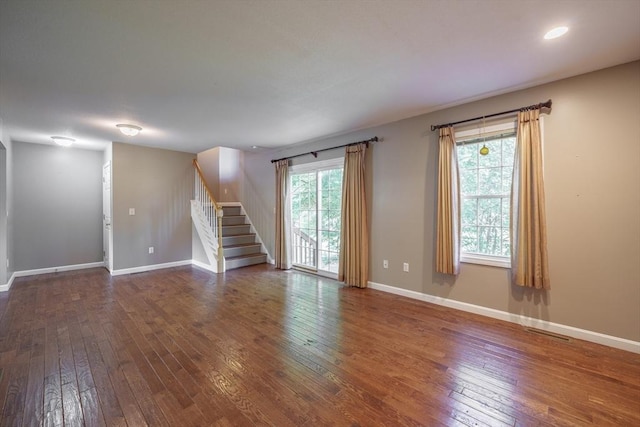 unfurnished room featuring stairs, hardwood / wood-style flooring, baseboards, and recessed lighting