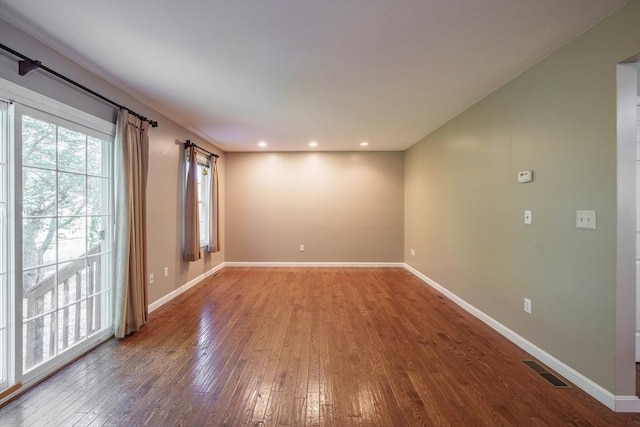 spare room with hardwood / wood-style floors, baseboards, and recessed lighting