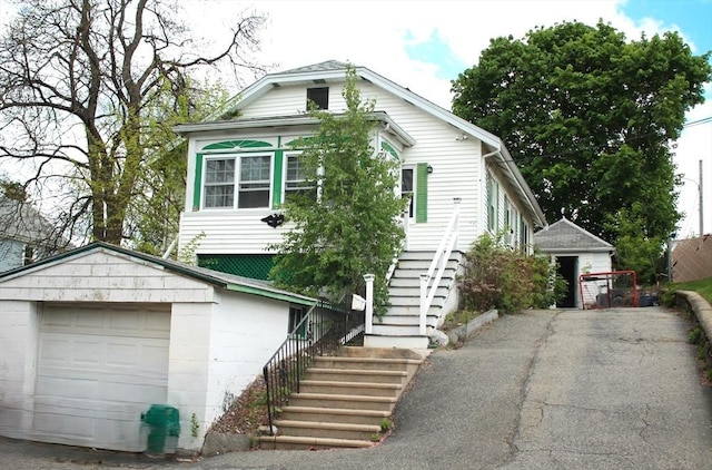 64 Garfield Ave, Woburn, MA 01801 - view of front facade with stairway, a garage, and an outbuilding