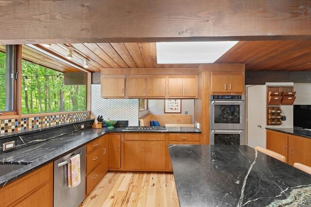 183 Indian Hl, Carlisle, MA 01741 - kitchen with appliances with stainless steel finishes, light wood-type flooring, wooden ceiling, tasteful backsplash, and dark stone countertops
