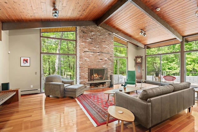 183 Indian Hl, Carlisle, MA 01741 - living room with a baseboard radiator, light wood-style floors, a brick fireplace, wooden ceiling with exposed beams, and high vaulted ceiling