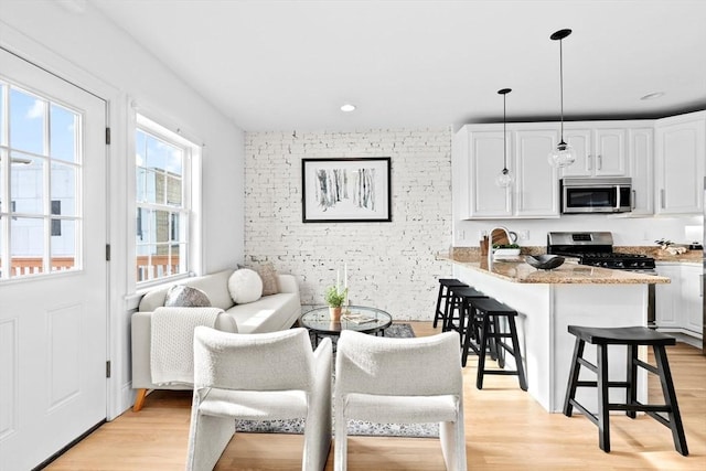 interior space featuring light wood-style floors, recessed lighting, and brick wall