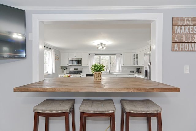 197 N St, Mattapoisett, MA 02739 - kitchen with appliances with stainless steel finishes, butcher block countertops, a peninsula, and white cabinets
