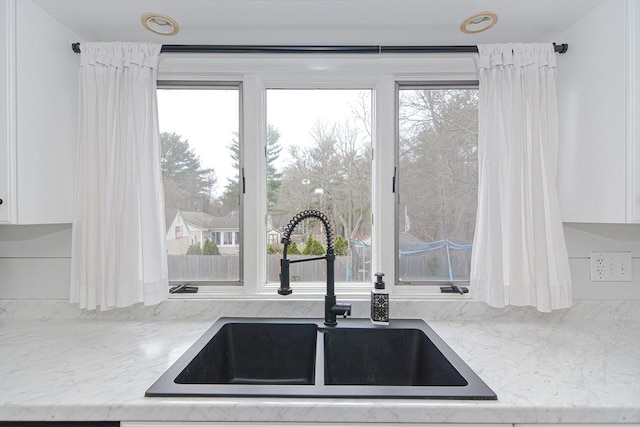 197 N St, Mattapoisett, MA 02739 - kitchen view of a sink, white cabinets, and light stone countertops
