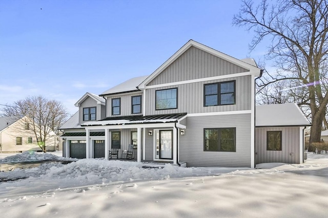 modern inspired farmhouse with a porch, metal roof, board and batten siding, and a garage