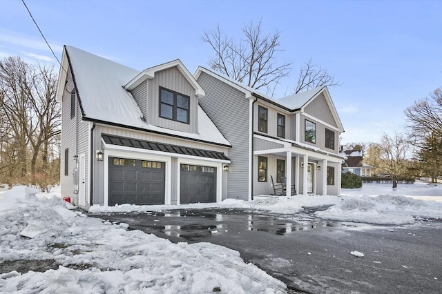 view of front facade featuring a garage, a standing seam roof, and metal roof