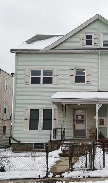 townhome / multi-family property featuring a fenced front yard and covered porch